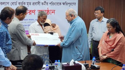 প্রবাসে মৃত কর্মীর পরিবারের হাতে ক্ষতিপূরণের চেক বিতরণ করা হচ্ছে