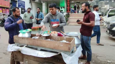 রাস্তায় দাঁড়িয়ে শীতের পিঠা খাচ্ছেন পিঠাপ্রেমীরা