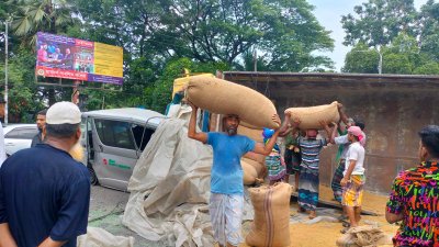 সরিয়ে নেওয়া হচ্ছে ট্রাকের ধান (ছবি: বাংলা ট্রিবিউন)