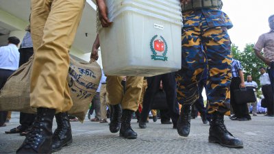 কেন্দ্রে ব্যালট বক্স নিয়ে যাচ্ছেন আইনশৃঙ্খলা রক্ষাকারী বাহিনীর কয়েকজন সদস্য/ঢাকা ট্রিবিউন