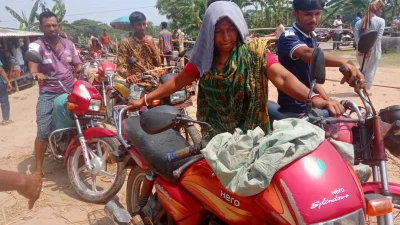 সাতীক্ষার শ্যামনগরের মুন্সীগঞ্জ ফিলিং স্টেশনে ছেলের মোটরসাইকেলের তেলের জন্য দাঁড়িয়ে আছেন মা বিথিকা রানী বৈদ্য। ছবি: বাংলা ট্রিবিউন