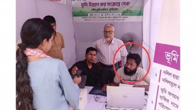 পৌর ভূমি অফিসের স্টলে রবিউল ইসলাম পলিন (গোল চিহ্নিত)। পেছনে দাঁড়িয়ে আছেন কুড়িগ্রাম পৌর ভূমি অফিসের ইউনিয়ন ভূমি সহকারী কর্মকর্তা (তহশিলদার) আব্দুল হাকিম শেখ