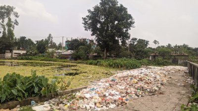 পুকুর পাড়ে হাসপাতালের বর্জ্য ফেলা হচ্ছে। পুকুরের পানিতে ছড়িয়ে পড়েছে বর্জ্য