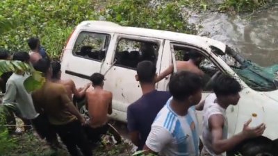 খাদে পড়ে যাওয়া গাড়িটি টেনে তুলছেন স্থানীয়রা