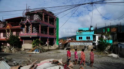 নেপালের নুয়াকোট জেলার দেবীঘাটে আকস্মিক বন্যার তাণ্ডব শেষে ধ্বংসস্তূপের পাশ দিয়ে হেঁটে যাচ্ছেন সাধারণ মানুষরা। ছবি: এপি