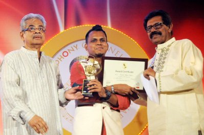 কিংবদন্তি দুই গীতিকবির কাছ থেকে পদক নিচ্ছেন রবিউল ইসলাম জীবন।