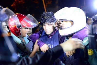 এক আহত পুলিশ কর্মকর্তাকে সহকর্মীরা নিয়ে যাচ্ছেন