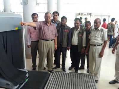 স্থলবন্দরে কনভেয়ার বেল্টের সামনে শুল্ক গোয়েন্দাদের একটি দল