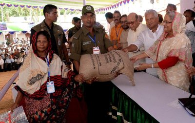 প্রধানমন্ত্রী শেখ হাসিনার হাত থেকে দশ টাকা দরে চাল ও কার্ড নিচ্ছেন কুড়িগ্রামের এক নারী