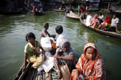 নৌকায় করে গুলশান এলাকার কোরাইল বস্তিতে আসছে মানুষ (২০১৩ সালের ছবি)