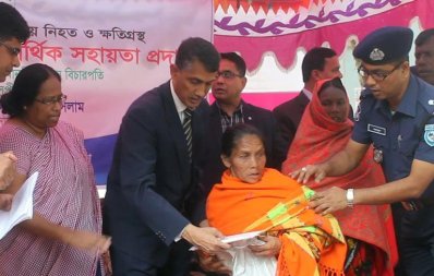 ক্ষতিগ্রস্ত সাঁওতালদের হাতে টাকা তুলে দেন রেজিস্ট্রার আমিনুল ইসলাম