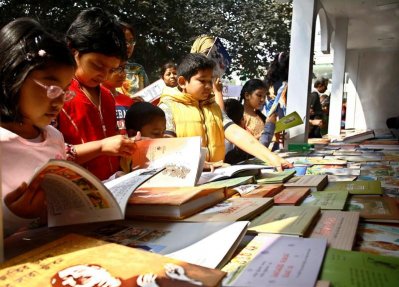 বইমেলার একটি স্টলে বই দেখছে ক্ষুদে পাঠকরা