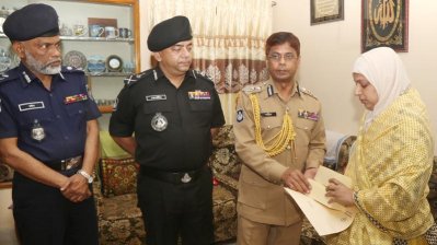 কর্নেল আজাদের স্ত্রীর হাতে চেক তুলে দিচ্ছেন আইজিপি শহীদুল হক
