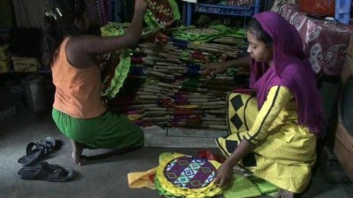তৈরির পর হাতপাখাগুলো স্তুপ করে রাখছে দুই শিশু (ছবি- বাংলা ট্রিবিউন)