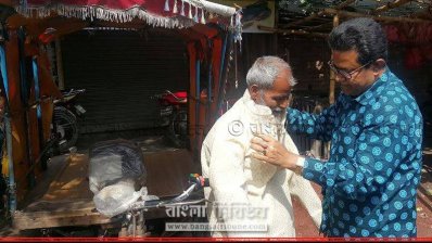 নিজ হাতে ভ্যানচালককে পাঞ্জাবি পরিয়ে দিচ্ছেন এমপি জগলুল (ছবি- সাতক্ষীরা প্রতিনিধি)