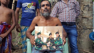 ছেলের ছবি হাতে রাঙামাটিতে নিহত সেনা সদস্য আজিজুরের বাবা (ছবি-মাদারীপুর প্রতিনিধি)
