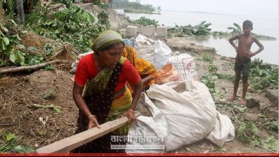 সরিয়ে নেওয়ার জন্য প্রয়োজনীয় মালামাল গুছাচ্ছেন এক নারী (ছবি-সিরাজগঞ্জ প্রতিনিধি)