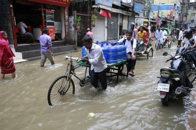 পানি জমে থাকা নাজিমউদ্দিন রোড ভ্যানে পারাপার