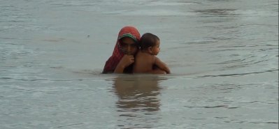 কুড়িগ্রামে ত্রাণের আশায় শিশু সন্তানকে কোলে নিয়ে যাচ্ছেন এক মা (ছবি- কুড়িগ্রাম প্রতিনিধি)