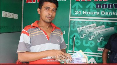 বুথের সামনে জাল টাকা নিয়ে অভিযোগকারী ইমন। ছবি-প্রতিনিধি