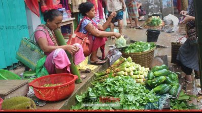 বাজারে আদিবাসী নারীরা বেচা-কেনা করছে