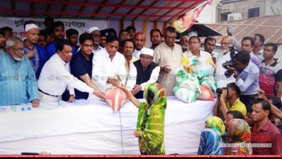 বন্যাদুর্গতদের হাতে ত্রাণ বিতরণ করছেন ত্রাণমন্ত্রী মোফাজ্জল হোসেন চৌধুরী (ফাইল ছবি)