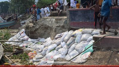 বালুর বস্তা ফেলে পাউবোর ভাঙন রোধের চেষ্টা (ছবি- প্রতিনিধি)
