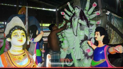 প্রতিমার গায়ে রঙের আঁচড় দিতে ব্যস্ত কারিগর (ছবি প্রতিনিধি)