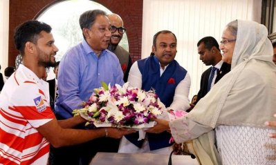 প্রধানমন্ত্রীর হাতে ফুলের তোড়া তুলে দিচ্ছেন মাশরাফি। ছবি-বিসিবি