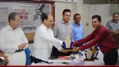 বর্ষসেরা সাংবাদিকের হাতে ক্রেস্ট তুলে দিচ্ছেন প্রধানমন্ত্রীর তথ্য উপদেষ্টা