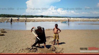 কয়লার সন্ধানে বালু খুঁড়ছেন এক নারী শ্রমিক (ছবি- প্রতিনিধি)