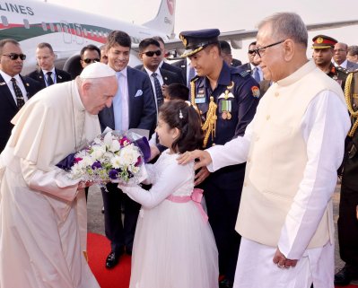 হযরত শাহজালাল আন্তর্জাতিক বিমানবন্দরে নামার পর রাষ্ট্রপতি মো. আবদুল হামিদ পোপ ফ্রান্সিকে স্বাগত জানান। এসময় একটি শিশু তার হাতে ফুলের তোড়া তুলে দেয়। (ছবি: ফোকাস বাংলা)