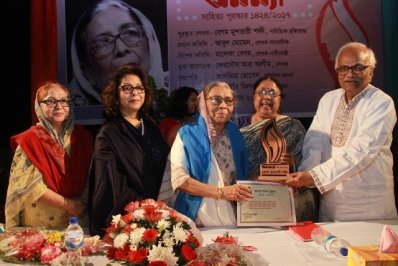 বেগম মুশতারী শফীর হাতে পুরস্কারের ক্রেস্ট তুলে দিচ্ছেন কবি ও সাংবাদিক আবুল মোমেন