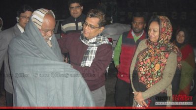 এক শীতার্তের গায়ে কম্বল জড়িয়ে দেন জেলা প্রশাসক জাকির হোসেন