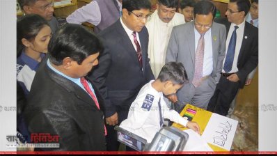 সততা স্টোর উদ্বোধনের পর শিক্ষা উপকরণ কিনছে এক শিক্ষার্থী