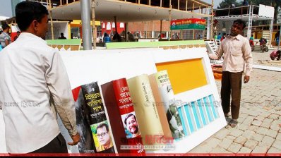 পাঠকদের স্বাগত জানাতে প্রায় প্রস্তুত বইমেলার স্টলগুলো (ছবি- নাসিরুল ইসলাম)