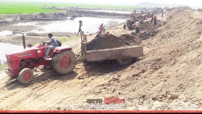 দূর থেকে ট্রাক্টরে করে মাটি আনা হচ্ছে