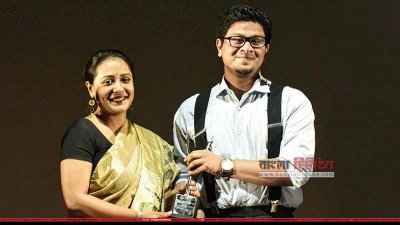 অপি করিমের কাছ থেকে পুরস্কার নিচ্ছেন নুহাশ