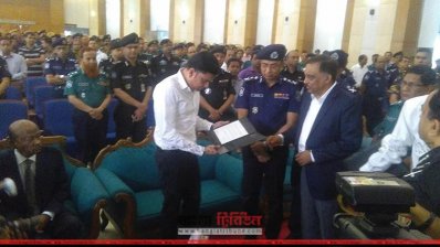 এক স্বজনের হাতে স্মারক তুলে দিচ্ছেন স্বরাষ্ট্রমন্ত্রী ও আইজিপি
