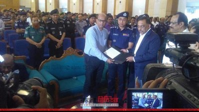 এক স্বজনের হাতে স্মারক তুলে দিচ্ছেন স্বরাষ্ট্রমন্ত্রী ও আইজিপি