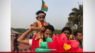 বাবার কাঁধে চড়ে শহীদদের প্রতি শ্রদ্ধা জানাতে এসেছে এক শিশু
