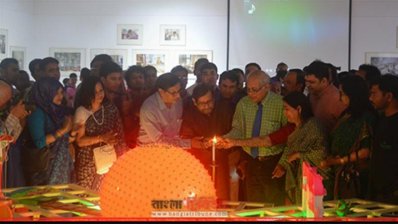 মোম জ্বালিয়ে আলোকচিত্র প্রদর্শনী উদ্বোধন করছেন আসাদুজ্জামান নূর