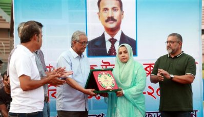 খাজা রহমতউল্লাহর স্ত্রীর হাতে ক্রেস্ট তুলে দিচ্ছেন হকি ফেডারেশনের সাধারণ সম্পাদক আব্দুস সাদেক 
