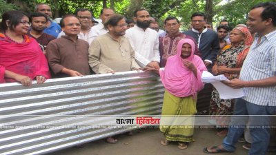 গৃহনির্মাণ সামগ্রী বিতরণ করছেন সংস্কৃতিমন্ত্রী
