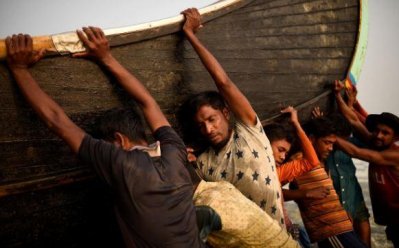 নৌকা ঢেলে সাগরে নামানোর কাজ করছে রোহিঙ্গা শিশু-কিশোররা