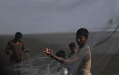 জাল মেরামতের কাজ করছে এক রোহিঙ্গা শিশু