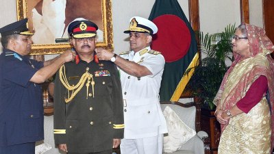প্রধানমন্ত্রীর উপস্থিতিতে নবনিযুক্ত সেনাবাহিনী প্রধান আজিজ আহমেদকে জেনারেল র&zwnj;্যাংক ব্যাজ পরানো হচ্ছে, ছবি:(ফোকাস বাংলা) 