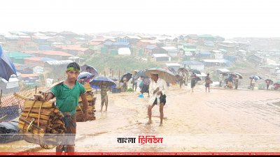 বৃষ্টির মধ্যে এক রোহিঙ্গা কিশোর জ্বালানি কাঠ সংগ্রহ করে নিয়ে যাচ্ছে
