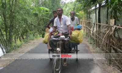 বিলুপ্ত ছিটমহল এলাকার রাস্তায় ভ্যান চালাচ্ছে একজন চালক