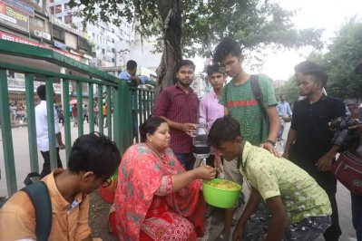 শিক্ষার্থীদের খিচুড়ি খাওয়াচ্ছেন এক মা